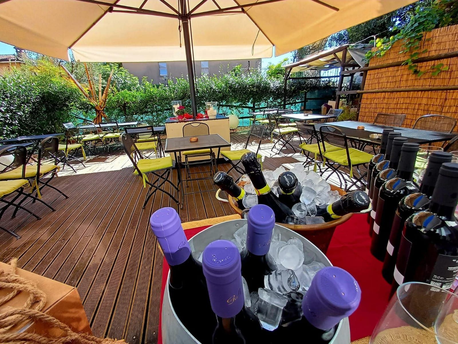 La terrazza esterna con ombrelloni, tavoli e vini