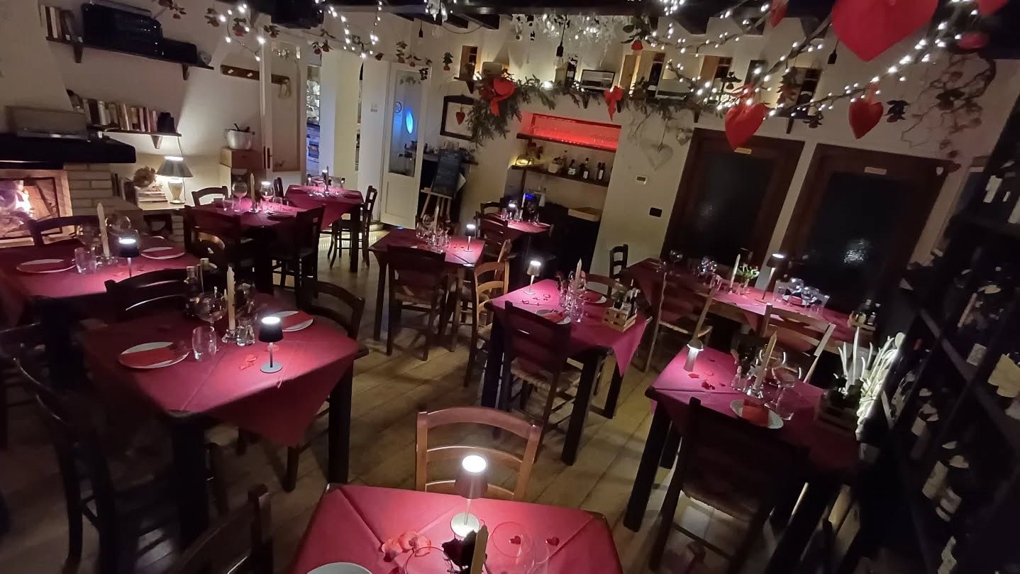 Sala dell’osteria apparecchiata con tovaglie color vino