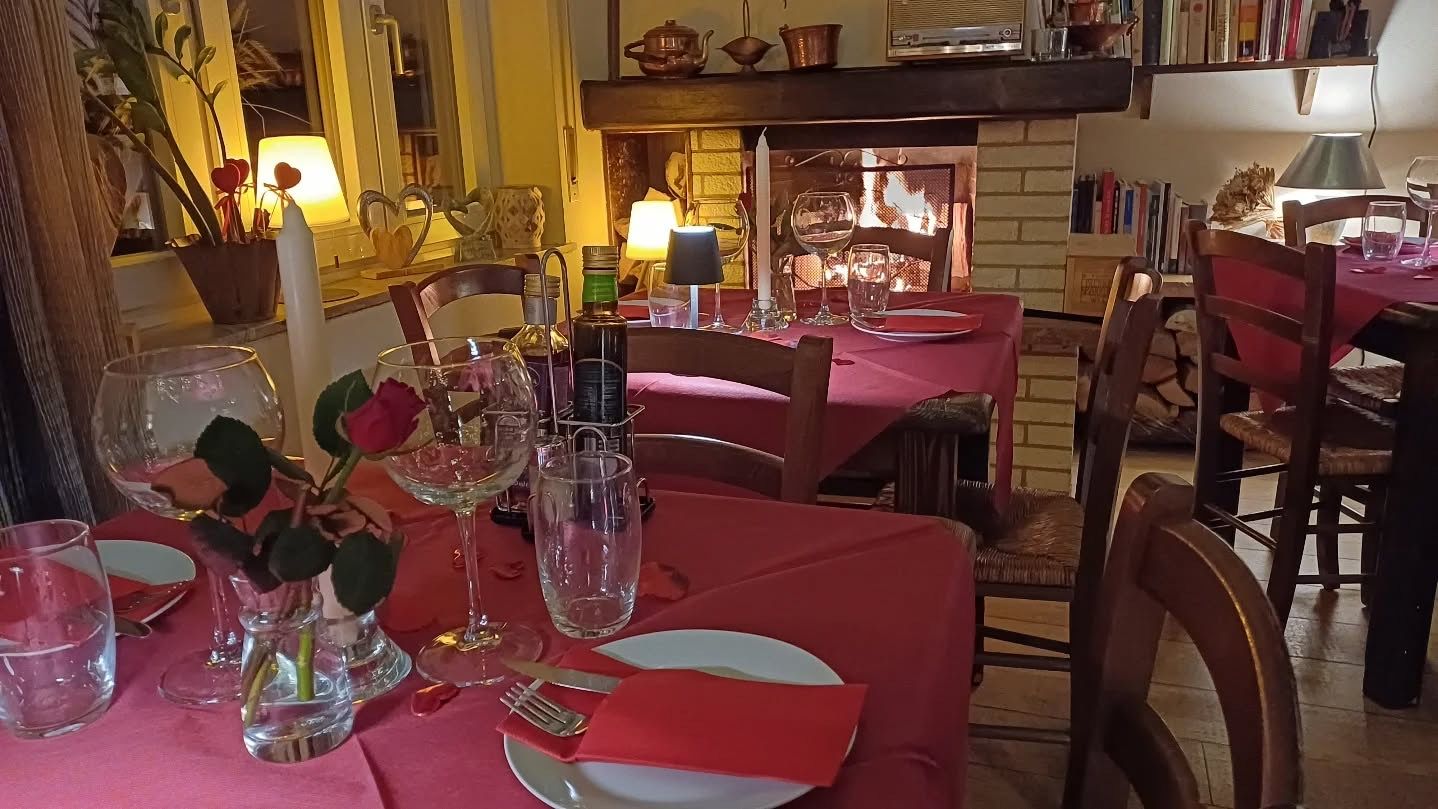 Sala interna apparecchiata con tavoli e fiori