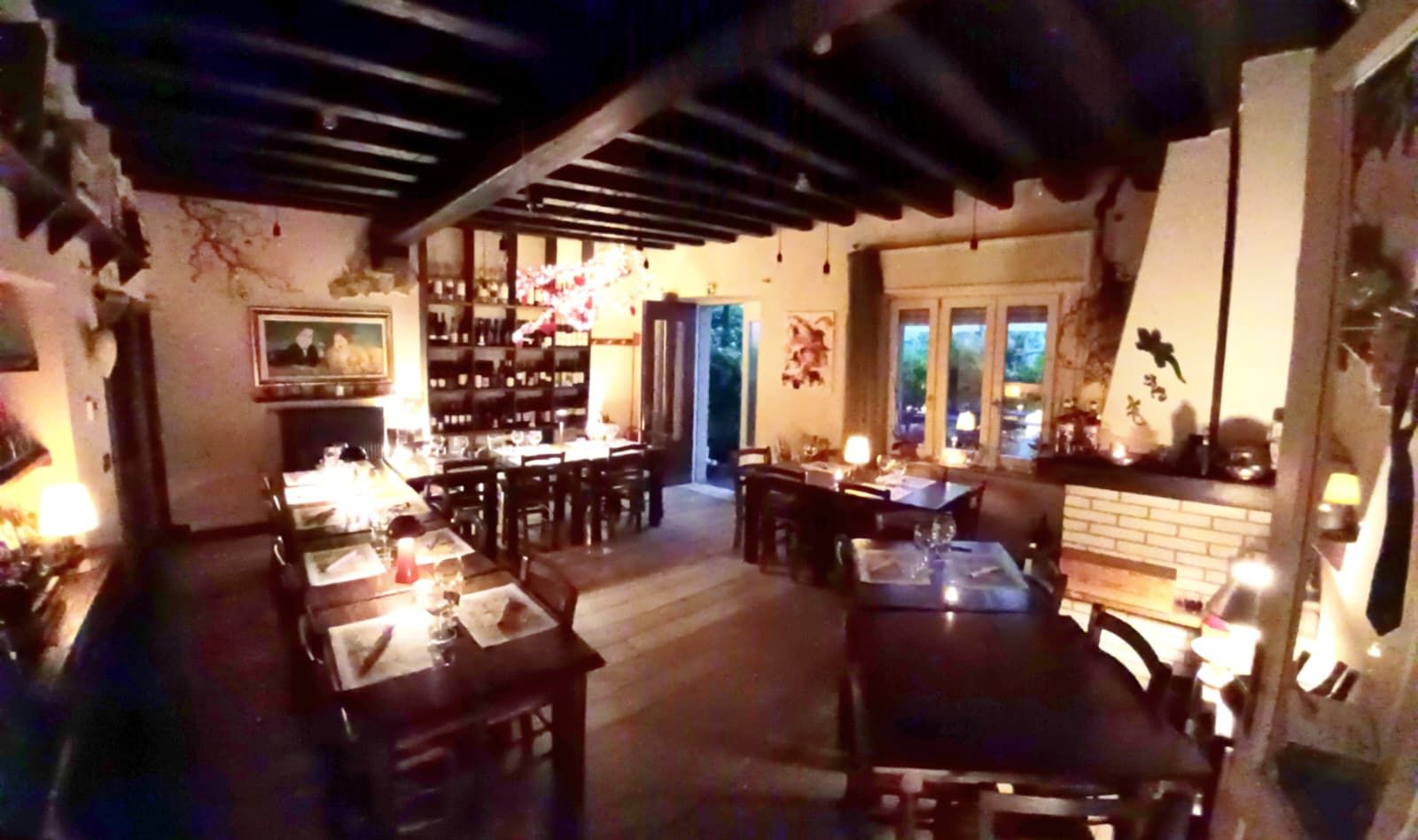 Sala dell’osteria con travi a vista e luci calde